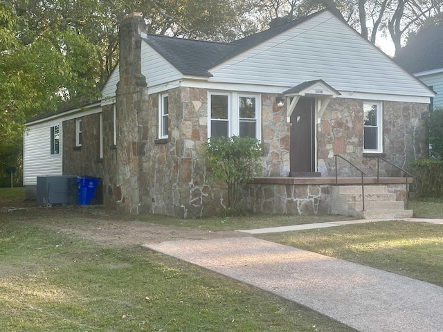 bungalow-style home with a front yard