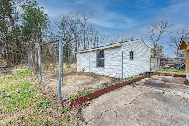 exterior space featuring a patio area, fence, and an outdoor structure