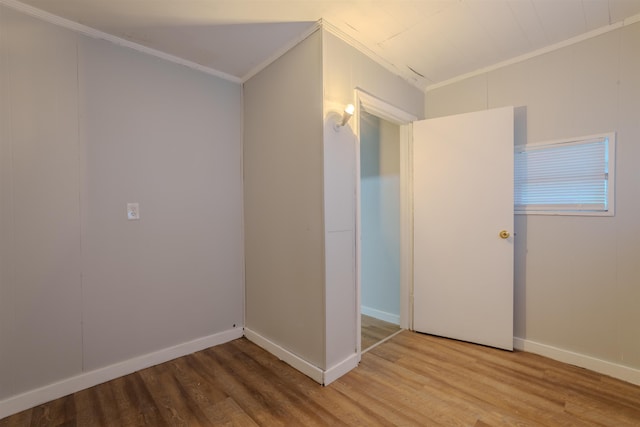 empty room featuring baseboards, ornamental molding, and wood finished floors