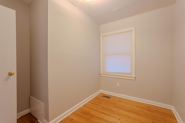 spare room featuring visible vents, light wood-style flooring, and baseboards