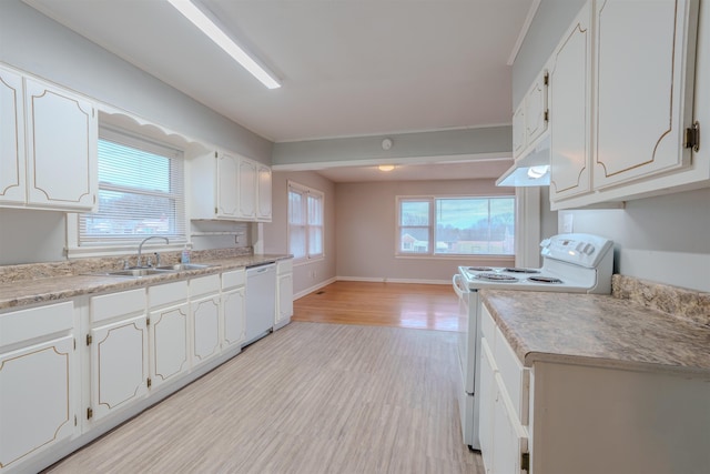 kitchen with white appliances, a wealth of natural light, white cabinets, light wood-style floors, and a sink