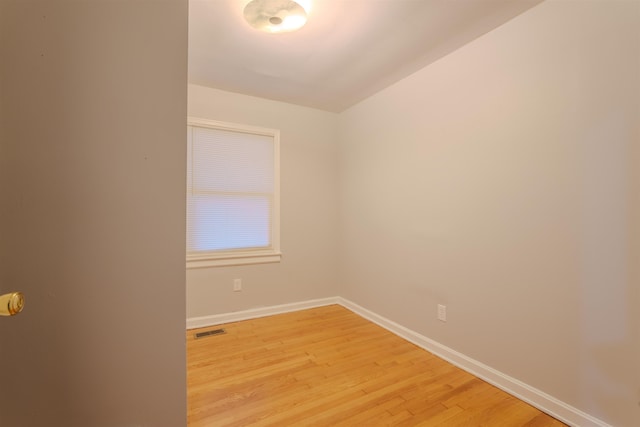 empty room with light wood finished floors, baseboards, and visible vents