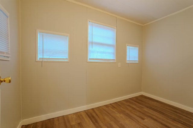 unfurnished room with ornamental molding, baseboards, and wood finished floors