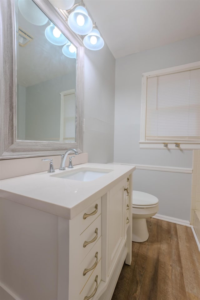 full bathroom featuring toilet, visible vents, wood finished floors, and vanity