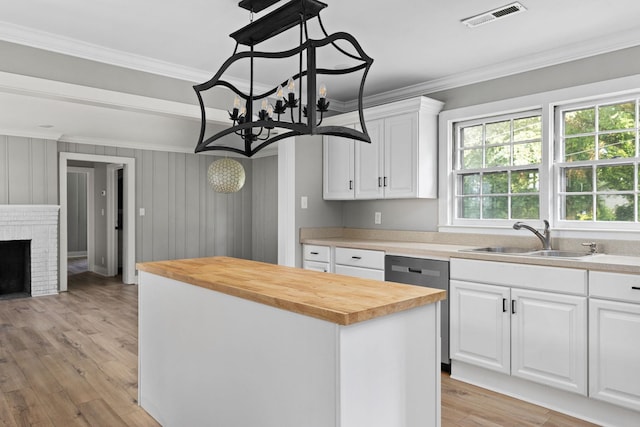  - kitchen with wood counters, dishwasher, crown molding, a kitchen island, and white cabinetry