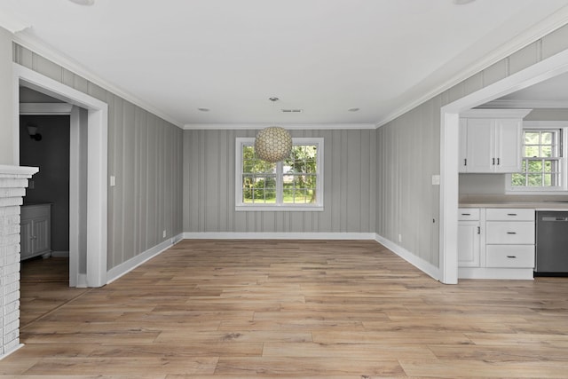  - unfurnished dining area with ornamental molding, light wood-type flooring, and a fireplace