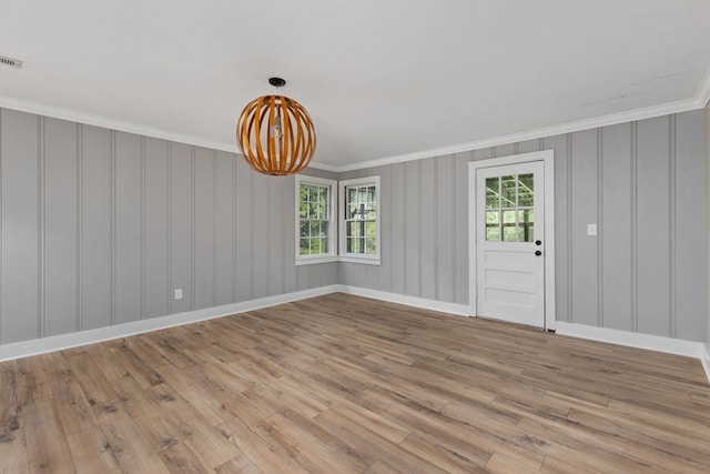  - empty room featuring wood finished floors and ornamental molding