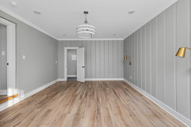  - spare room featuring light wood-style flooring, crown molding, a smoke detector, and a chandelier