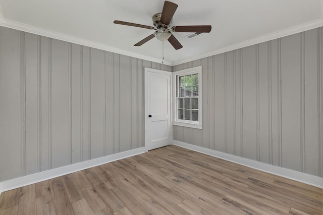  - spare room with wood finished floors, ornamental molding, and ceiling fan