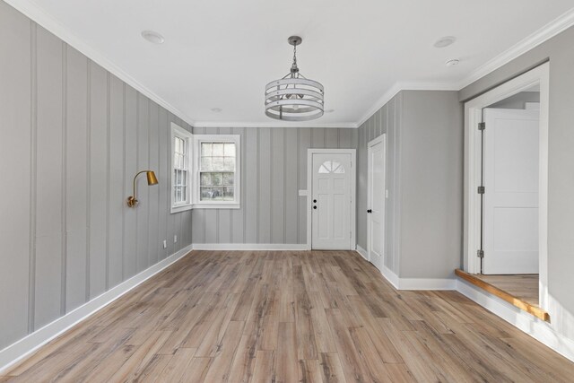  - foyer featuring light wood finished floors, ornamental molding, and a chandelier