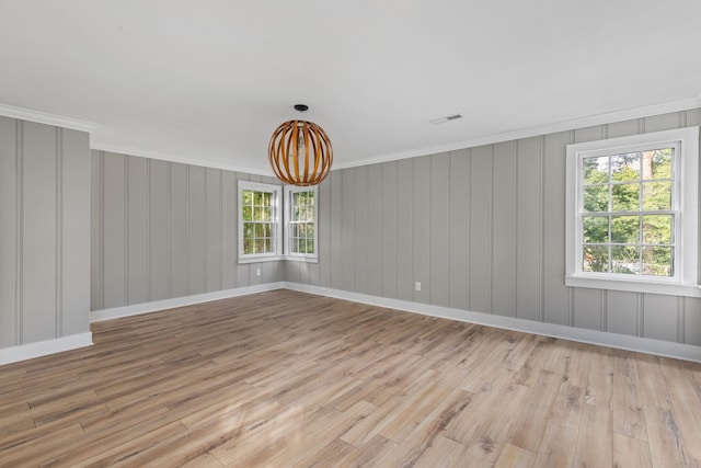  - empty room featuring light wood-type flooring, a chandelier, and ornamental molding