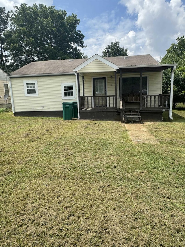 back of house featuring a porch and a lawn