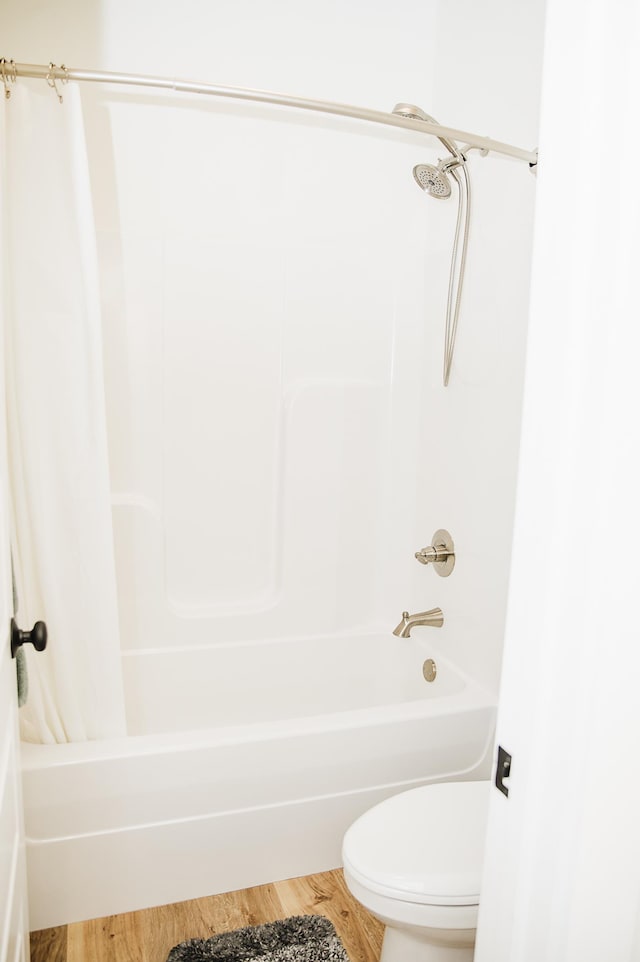 bathroom with toilet, shower / tub combo with curtain, and hardwood / wood-style flooring