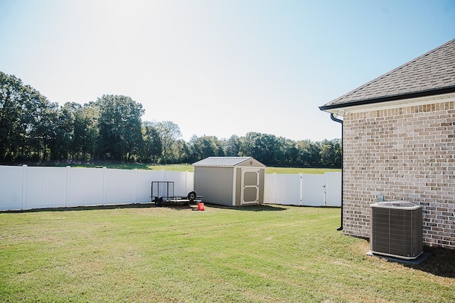 view of yard featuring central AC unit and a storage shed