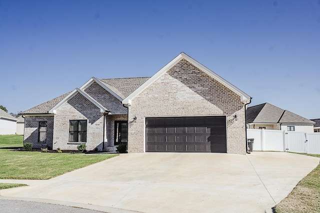 french provincial home featuring a front yard and a garage