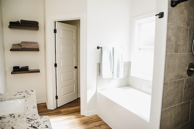 bathroom featuring a tub, sink, and hardwood / wood-style flooring