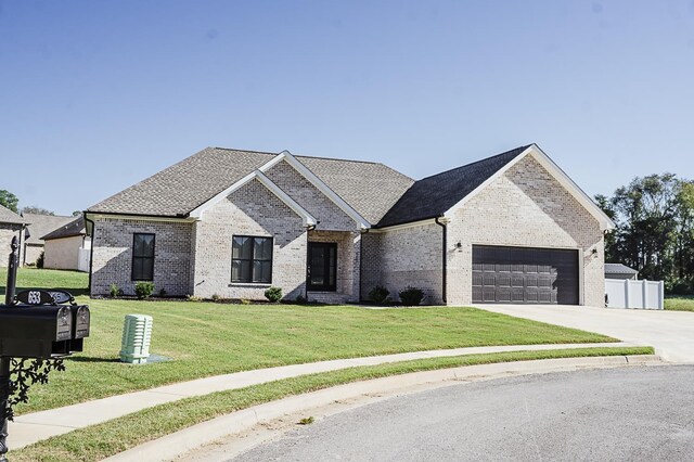 french country inspired facade featuring a garage and a front lawn