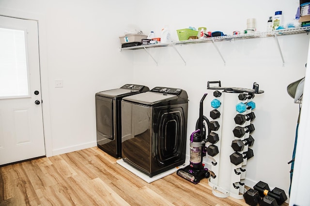 clothes washing area with wood-type flooring and independent washer and dryer