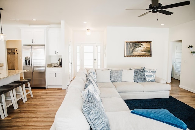 living room featuring light wood-type flooring and ceiling fan