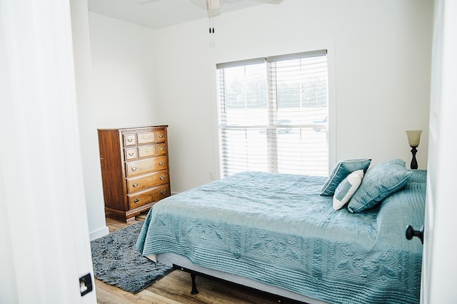 bedroom with hardwood / wood-style floors, multiple windows, and ceiling fan