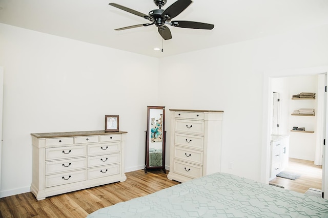 bedroom featuring ceiling fan, light hardwood / wood-style floors, and ensuite bath