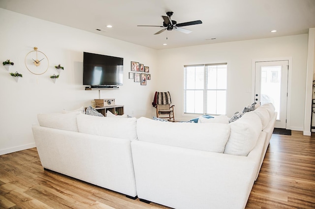 living room with light hardwood / wood-style flooring and ceiling fan