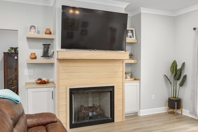 living room with crown molding, built in features, and light wood-type flooring