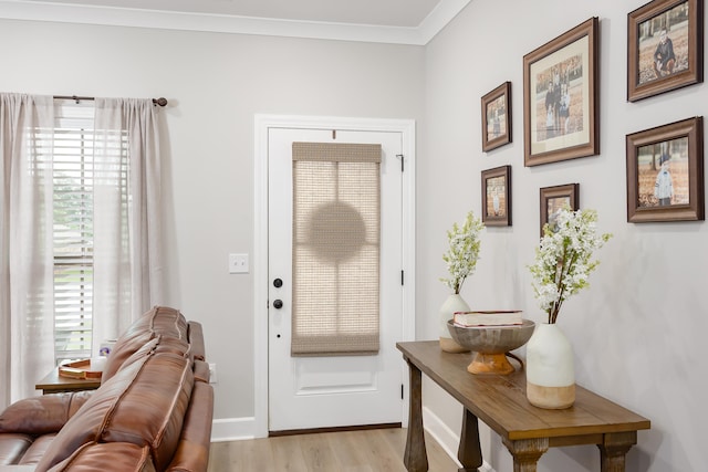 entryway with light wood-type flooring and ornamental molding