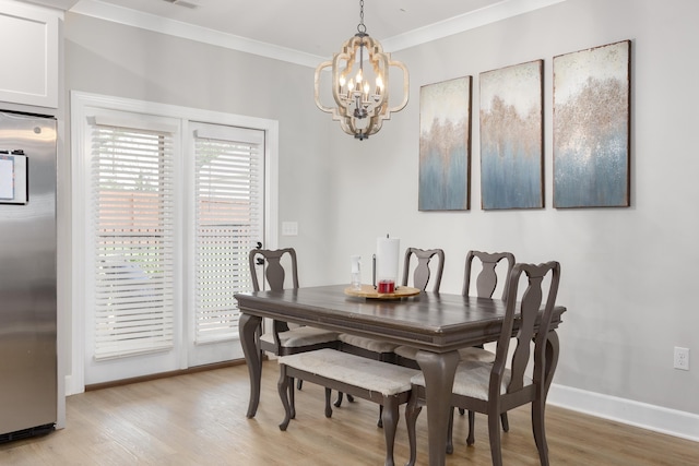 dining room featuring crown molding, light hardwood / wood-style floors, and a notable chandelier