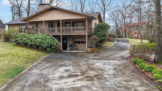 view of front of property featuring brick siding, a chimney, a front yard, a garage, and driveway