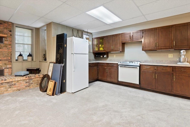 kitchen with white appliances, light countertops, light carpet, and a drop ceiling