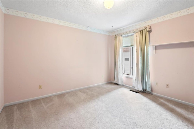 carpeted empty room featuring visible vents, a textured ceiling, and baseboards