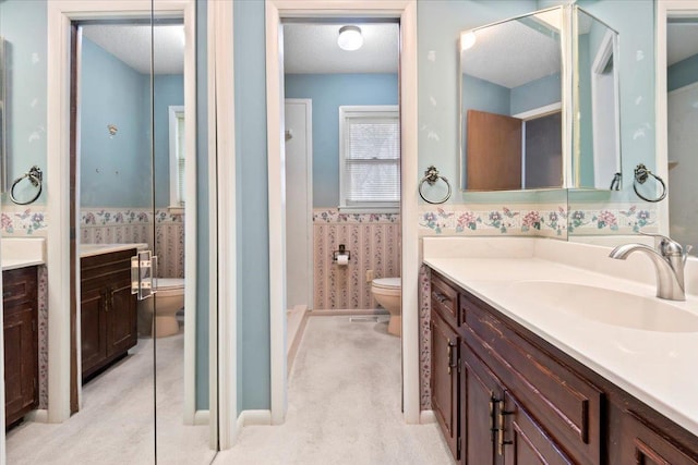 bathroom with a wainscoted wall, tile walls, toilet, a textured ceiling, and vanity