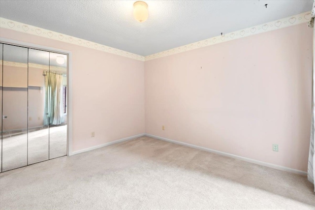 unfurnished bedroom featuring carpet, a closet, a textured ceiling, and baseboards