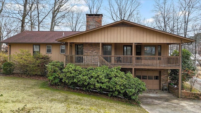 view of front of house featuring brick siding, a chimney, concrete driveway, a front yard, and a garage