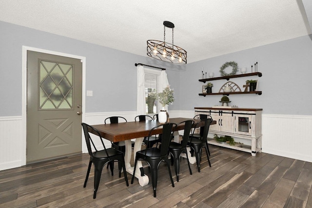 dining area with a chandelier, a textured ceiling, and dark hardwood / wood-style flooring