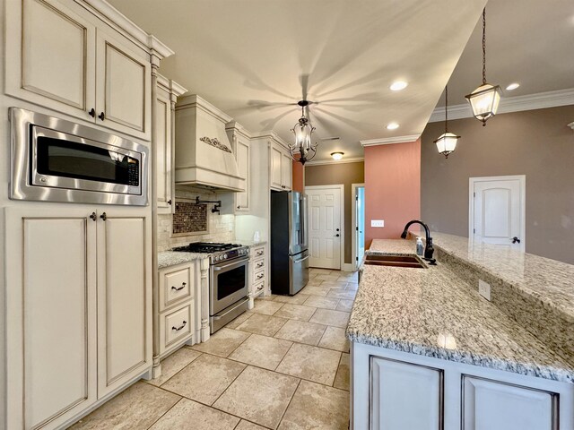 kitchen featuring light stone countertops, decorative light fixtures, stainless steel appliances, and sink