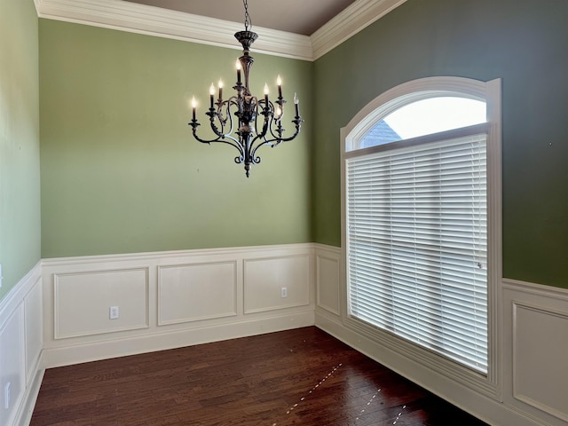 unfurnished room with an inviting chandelier, dark wood-type flooring, and crown molding