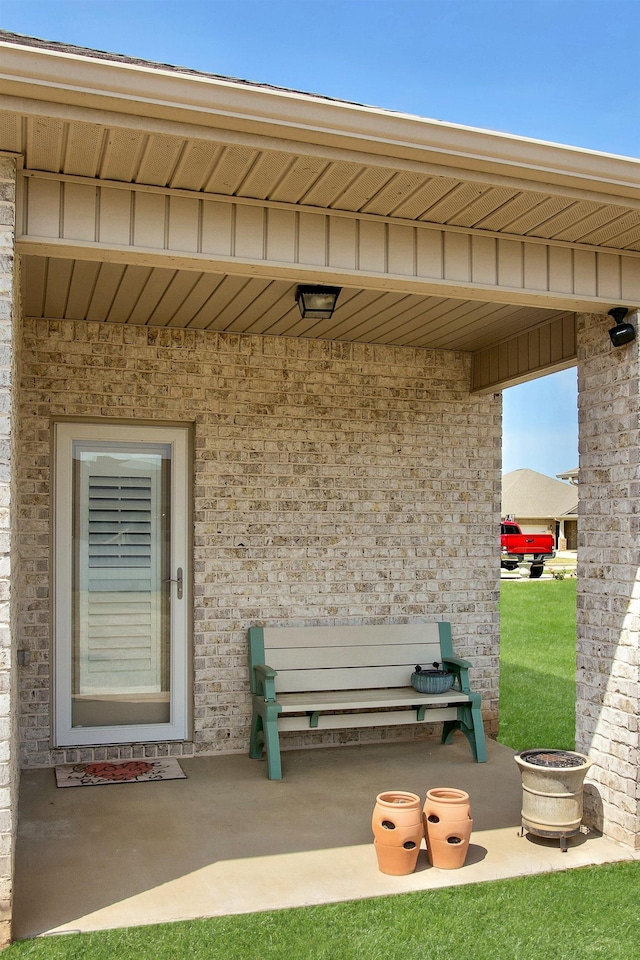  - entrance to property featuring brick siding and a patio area