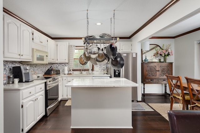 kitchen with backsplash, electric stove, dark hardwood / wood-style flooring, a kitchen island, and white cabinets