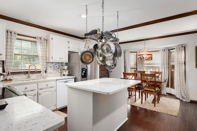 kitchen with tasteful backsplash, dishwasher, hanging light fixtures, a kitchen island, and white cabinets