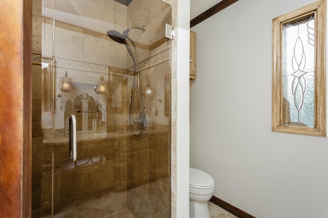 bathroom featuring toilet, ornamental molding, and a shower with shower door