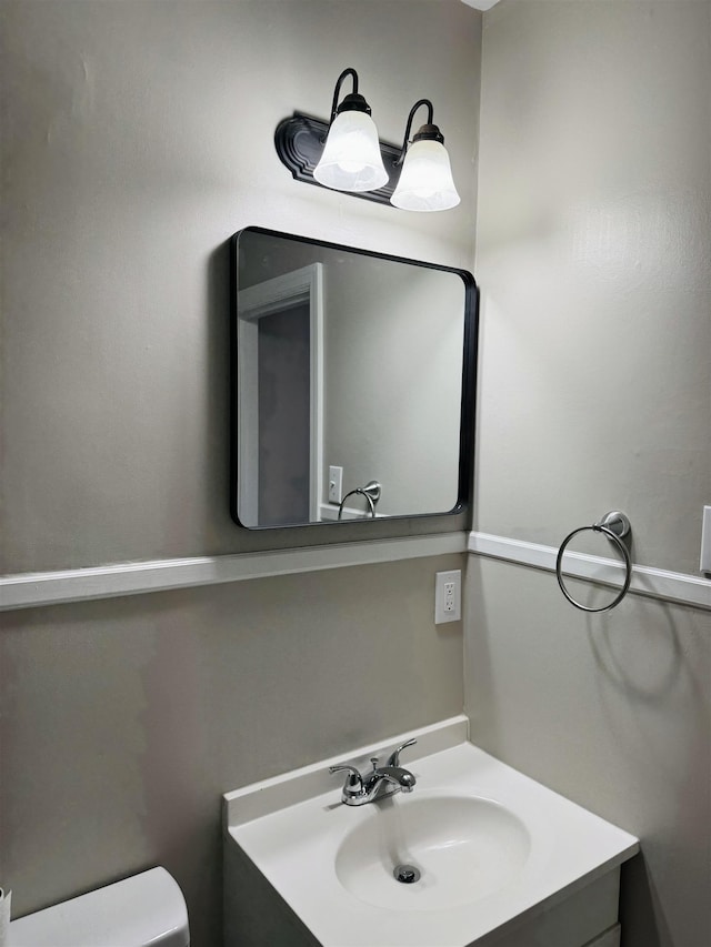 half bath featuring toilet and vanity