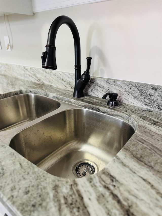 room details featuring a sink and light stone countertops