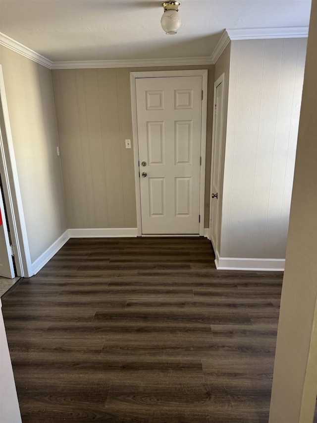 hall with dark wood-style floors, baseboards, and ornamental molding