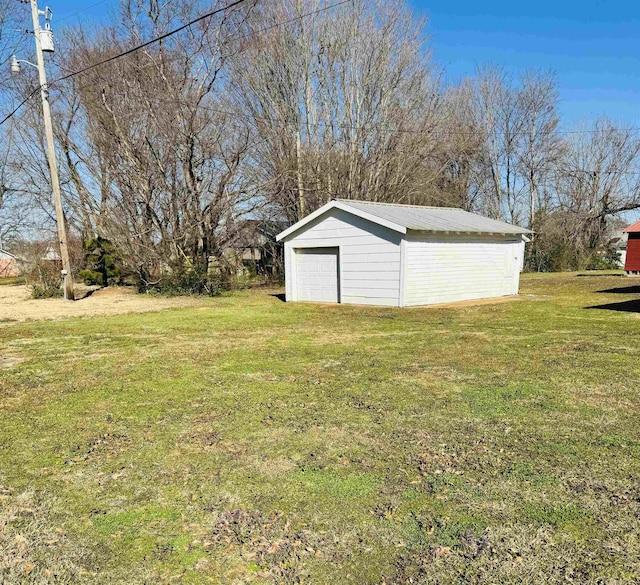 view of yard featuring a detached garage and an outdoor structure