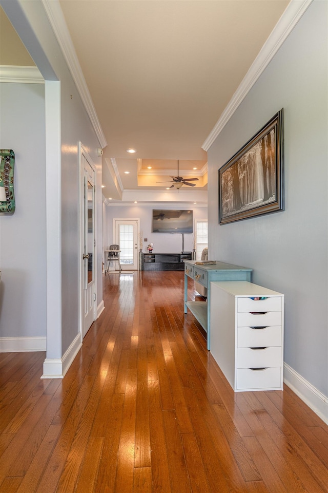  - hallway featuring wood-type flooring, a raised ceiling, and crown molding