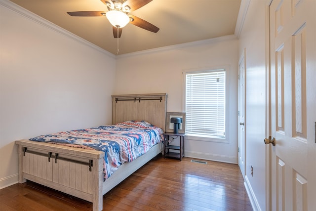  - bedroom with dark wood finished floors, ornamental molding, and ceiling fan