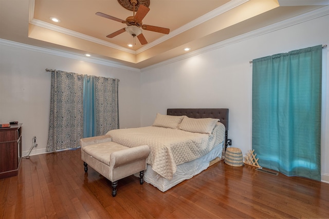  - bedroom featuring a tray ceiling, hardwood / wood-style flooring, crown molding, recessed lighting, and a ceiling fan