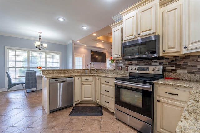  - kitchen with stainless steel appliances, a chandelier, cream cabinetry, a peninsula, and ornamental molding